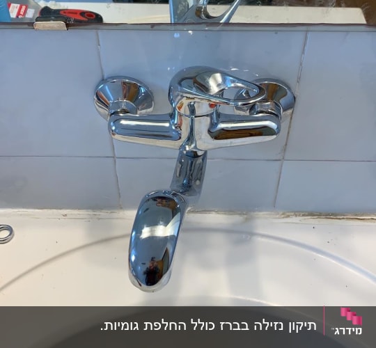 ברז כרום מעל כיור לבן עם מראה